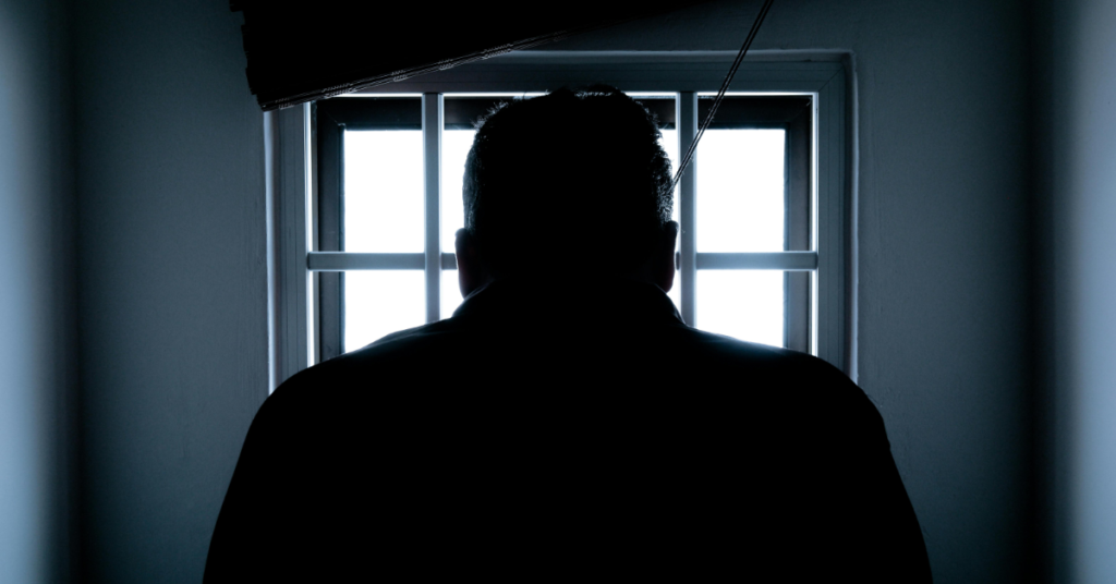 A silhouette of a person lit by a window