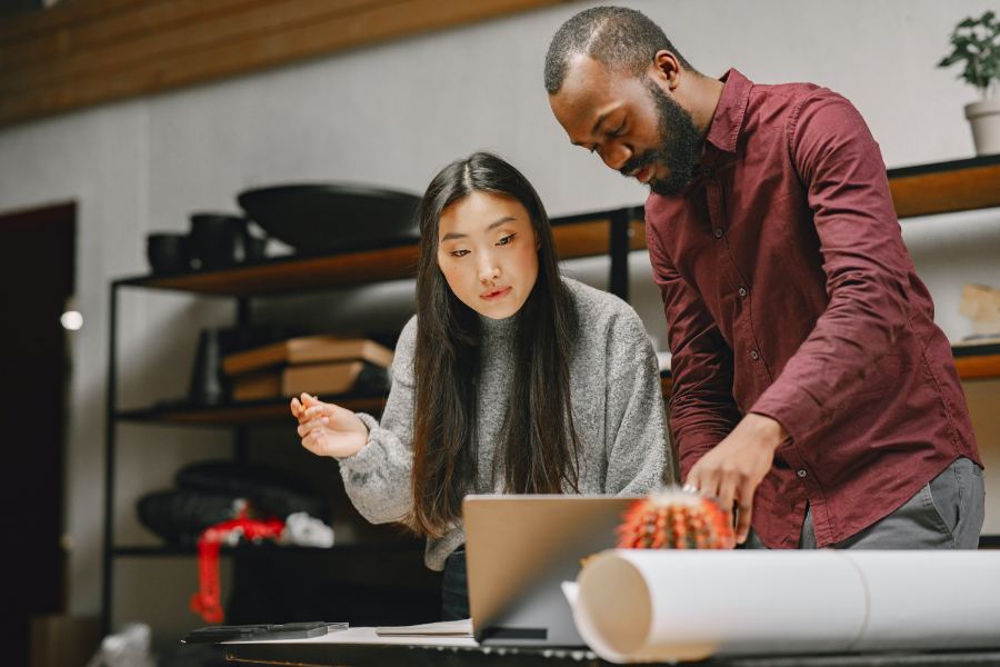 Two colleagues consulting at a workbench